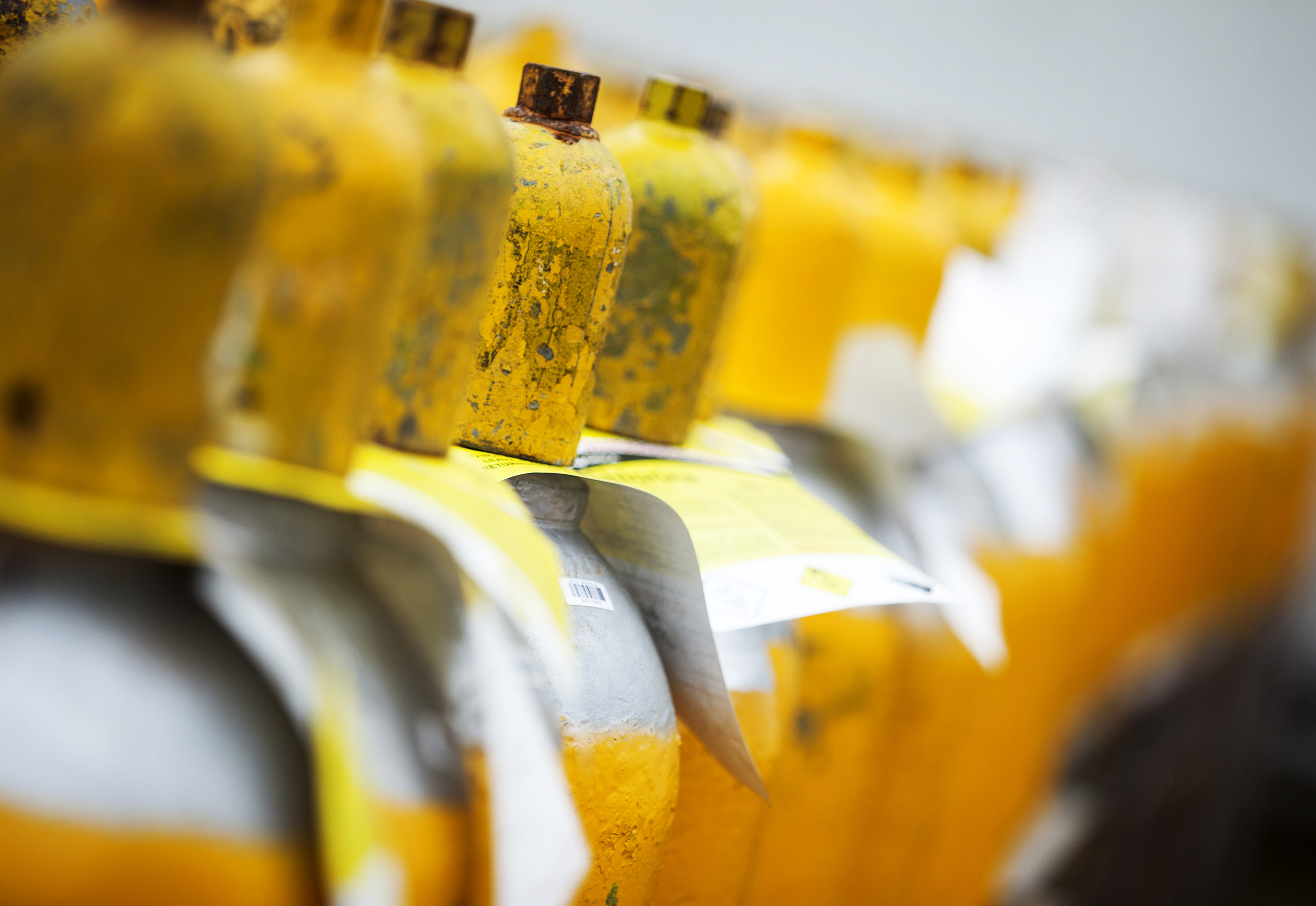 Yellow gas bottles in a line. Paul Scott Photography, industry.