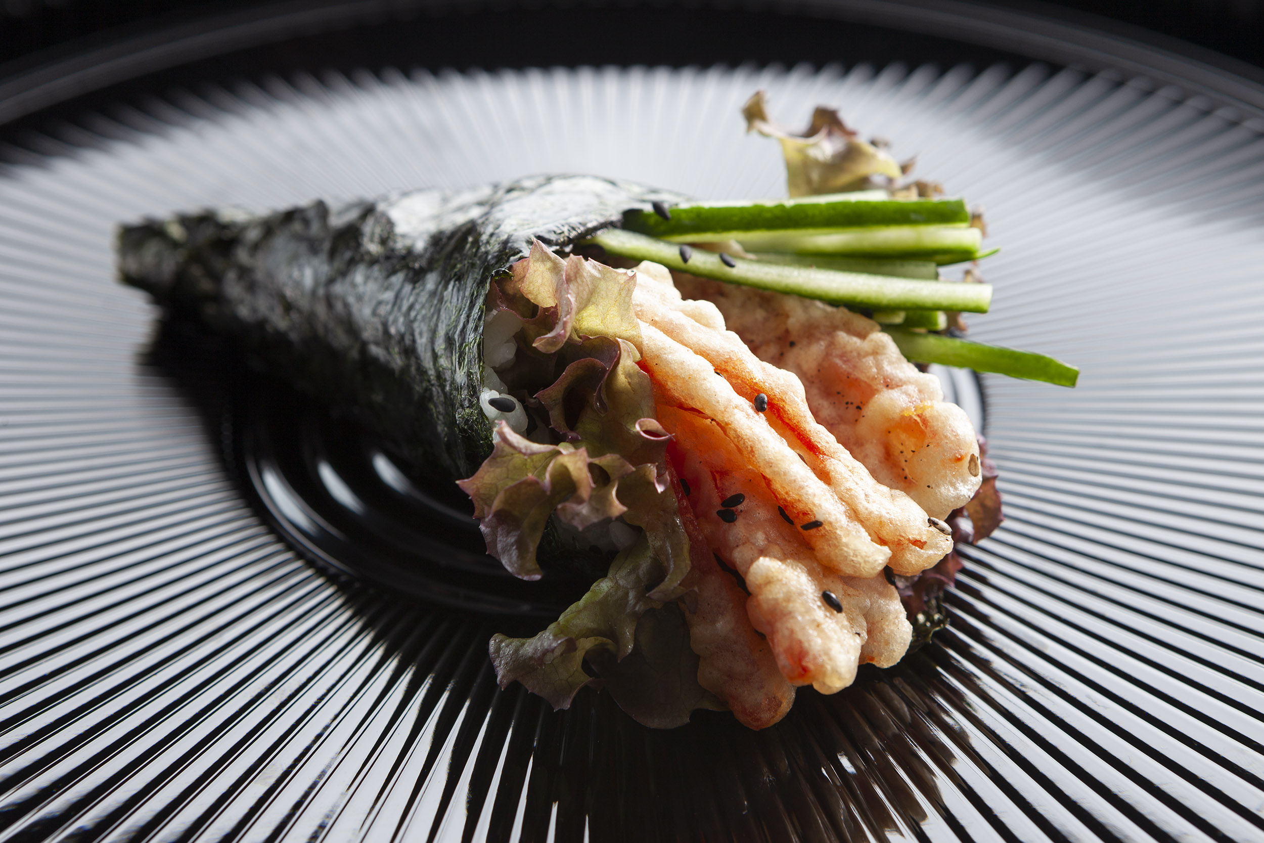 Sushi presented on a shiny black plate. Paul Scott, food.
